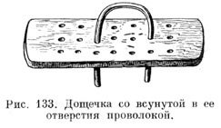 Дощечка со всунутойв ее отверстия проволокой