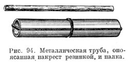 Металлическая труба, опоясанная накрест резинкой, и палка